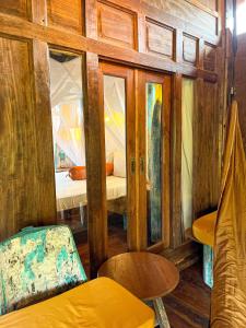 艾湄湾Blue Earth Village的木墙、一张床和椅子的房间