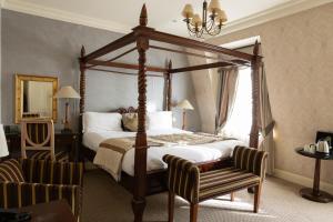 伦敦里奥纳德酒店的一间卧室配有一张天蓬床和一把椅子