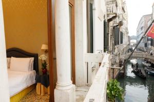威尼斯哥伦比亚酒店的一间设有一张床的客房,享有运河美景