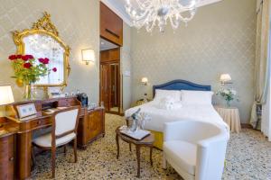 威尼斯哥伦比亚酒店的一间卧室配有一张床、一张书桌和一面镜子
