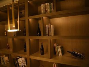 ZhongxingchangGya Hotel Chengdu Global Center Jinchenghu Metro Station的书架,装有葡萄酒瓶和书籍