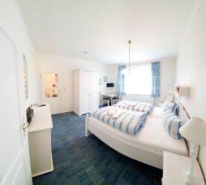 博尔库姆许贝特斯豪斯高级旅馆的卧室配有一张白色大床和一张书桌