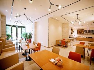 黄石City Comfort Inn Ezhou Huahu Airport High-speed Railway Station的一间带桌椅的用餐室和一间厨房