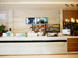 黄石City Comfort Inn Ezhou Huahu Airport High-speed Railway Station的两人站在餐厅柜台