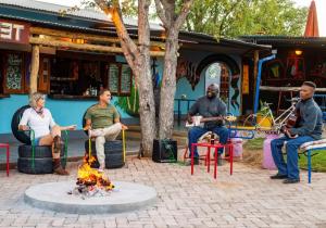 奥考奎约Etosha Safari Camp, Etosha National Park, Namibia的一群人坐在火坑周围