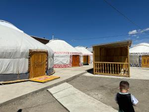 奥尔吉Traditional Yurts - Ulgii Guest House的站在一群帐篷前的一个男孩