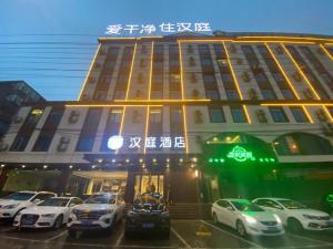 合肥Hanting Hotel Hefei Baoye Dongcheng Plaza的前面有汽车停放的建筑