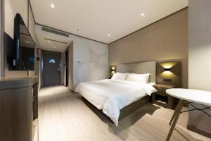 合肥Hanting Hotel Hefei Baoye Dongcheng Plaza的一间卧室配有一张床和一台平面电视