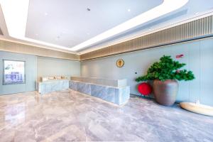 XingqianjieJi Hotel Wenzhou Economic Development Zone Binhai Park的一个大的大厅,在一个大的花瓶里种植植物