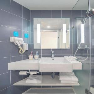 乌兰浩特Hanting Hotel Ulanhot Railway Station的浴室设有白色水槽和镜子