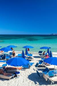 奥尔比亚斯特法尼亚海滩边酒店的海滩上的蓝色遮阳伞和椅子