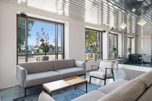 萨翁林纳托特夏季酒店的带沙发和桌子的客厅以及窗户。