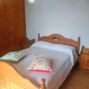 普莱伊亚诺Ulisse sul Sentiero的一间卧室配有一张带两个枕头的木床