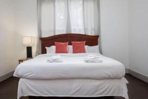 伯明翰East Lake Update-Close to Dining, 10min to Airport的卧室配有带红色枕头的大型白色床