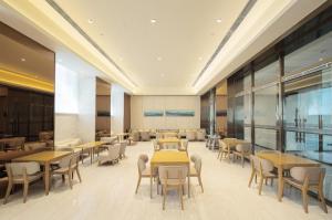 吉林Ji Hotel Jilin Wanda Plaza的大楼内带桌椅的用餐室