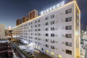 福山Hanting Premium Hotel Yantai Development Zone Golden Beach的白色的酒店,旁边标有标志