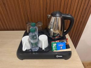 阿可贺巴شقق روز الفندقية دخول ذاتي的一个带水瓶的托盘和一张桌子上的茶壶
