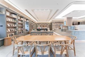 JinzhuzhenJi Hotel Guiyang Guanshan Lake High-Tech Zone的一间带木桌和椅子的用餐室