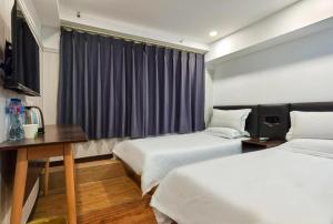 北京Hi Inn Beijing Chaoyangmen的酒店客房设有两张床和窗户。