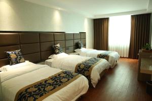 Ch'a-shan-chiehElan Boutique Hotel Wenzhou Longwan Haicheng的酒店客房设有三张床和窗户。