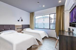 杭州Hi Inn Hangzhou Sijiqing Qiutao North Road的酒店客房设有两张床和大窗户。