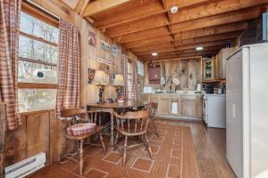 SlanesvilleTranquil Rocky Top Cabin with Mountain Views! cabin的厨房配有桌椅和冰箱。