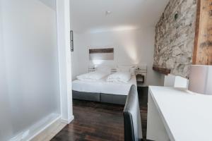 乌尔姆Design Hotel & Restaurant Löwen的一间卧室设有一张床和石墙