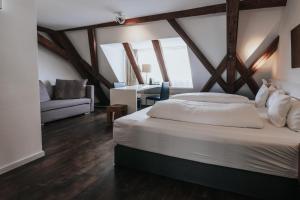 乌尔姆Design Hotel & Restaurant Löwen的一间卧室配有一张床、一张桌子和一张沙发