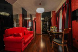 切拉诺Hotel Mastrodattia的客厅配有红色的沙发和桌子