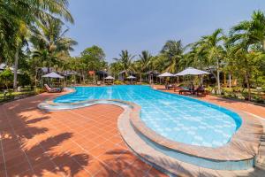 富国Dugong Resort Phu Quoc的棕榈树度假村的游泳池