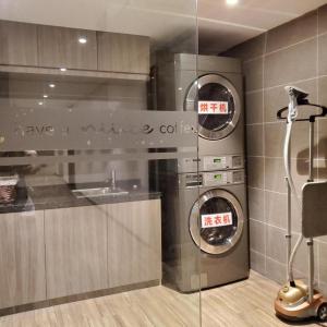 青岛Hanting Hotel Qingdao Xianggang Zhong Road Aofan Center的一间厨房,内设2台洗衣机和烘干机