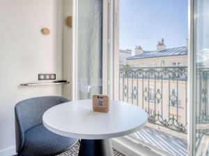 巴黎宜必思巴黎拉雪兹酒店的窗前的白色桌子和椅子