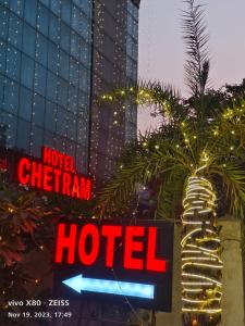 斋浦尔HOTEL CHETRAM ELITE near railway station的建筑前的酒店标志,带有酒店标志