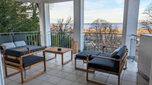 海瑞星阿莫斯LIBORIA I Villa mit Seeblick 10min vom See的阳台的门廊配有椅子和桌子