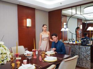 马尼拉Admiral Hotel Manila - MGallery的坐在餐厅桌子上的男女