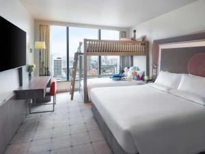 曼谷Novotel Bangkok Platinum Pratunam的酒店客房设有两张床和大窗户。