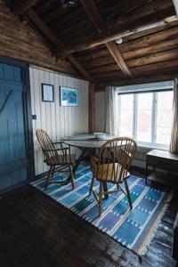 雷讷Reine Rorbuer - by Classic Norway Hotels的一间位于地毯上的带桌椅的用餐室