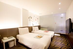 台北摩莎曼拉商旅-西门馆的酒店客房,设有两张床和一张沙发