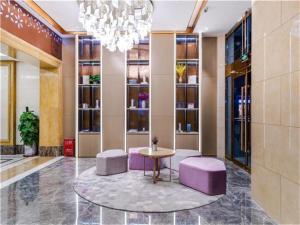 顺义Lavande Hotel Beijing Shunyi Shimen Metro Station的大堂设有紫色凳子、桌子和吊灯