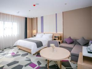 惠州Lavande Hotel Huizhou World Trade Center的酒店客房,配有床和沙发