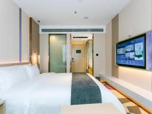 惠州Lavande Hotel Huizhou World Trade Center的配有一张床和一台平面电视的酒店客房