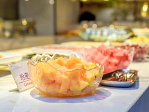 南充Lavande Hotel Nanchong Xihua Shida的桌子上放着一碗水果的桌子