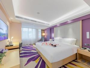 深圳Lavande Hotel Shenzhen Bay Houhai Avenue的酒店客房设有一张白色大床和紫色墙壁