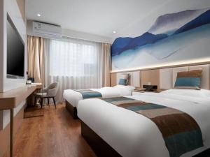 DonggaodiVX Hotel Beijing Daxing Wufutang Metro Station Zhongke Dianshanggu的一间酒店客房,设有两张床和电视