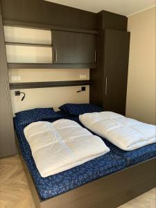 韦斯特卡佩勒Vakantiepark de Boomgaard的房间里的床上有两个白色枕头