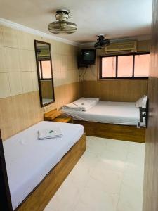 孟买Hotel Sagar Residency的带两张床和镜子的客房