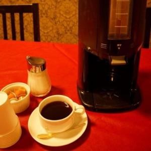 佐野市Hotel Miyoshino Annex的咖啡在红色桌子上喝杯咖啡,茶几上还有咖啡壶
