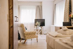 Laubach瓦尔德酒店的白色的客厅配有椅子和电视