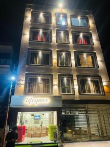 瑞诗凯诗Lifespace Rishikesh- Hotel, Hostel, Cowork, Cafe的前面有商店的大建筑