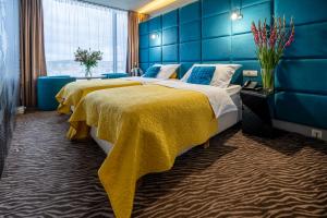 布尔诺索诺酒店的两张位于酒店客房的床,拥有蓝色的墙壁